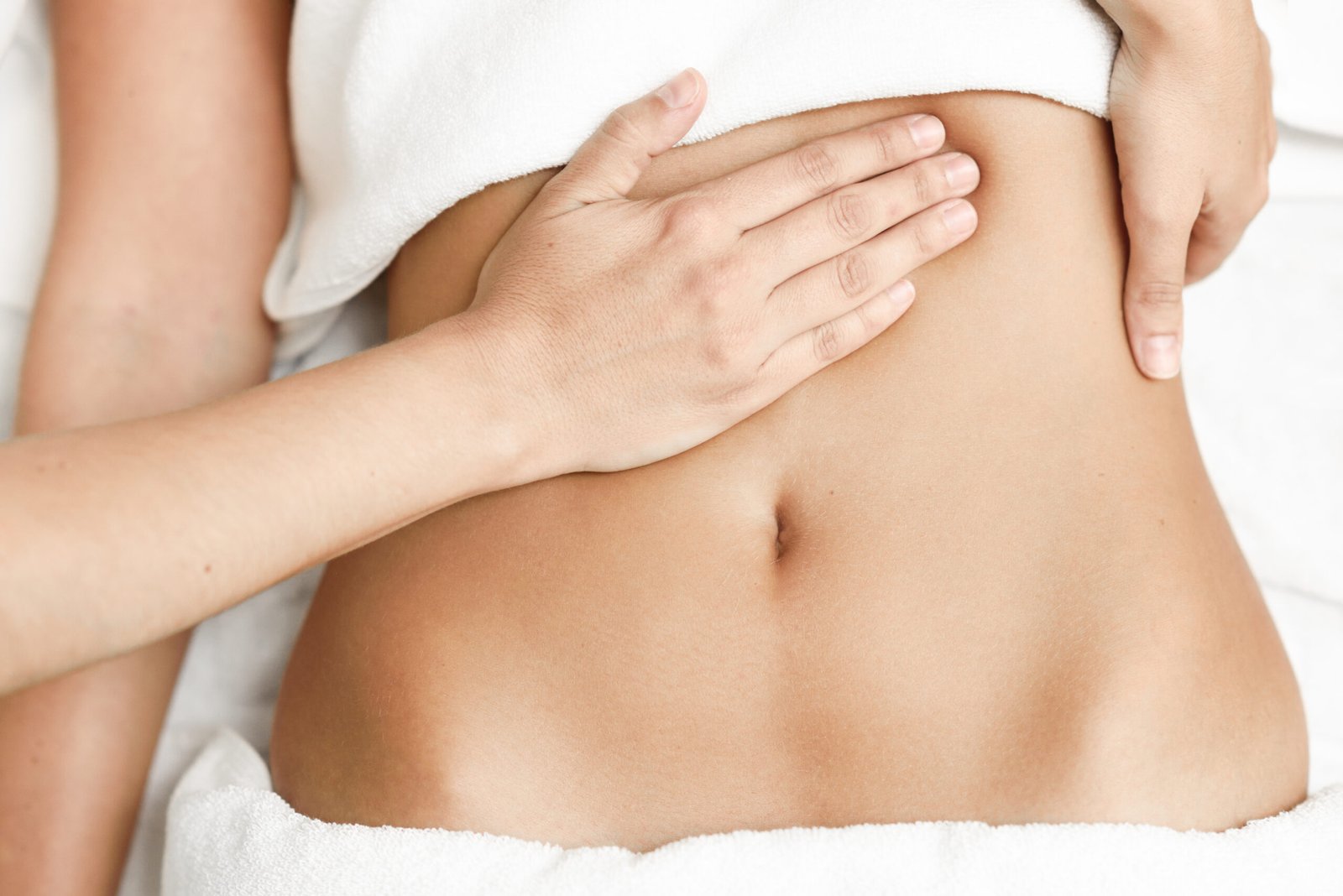 Hands massaging female abdomen.Therapist applying pressure on belly.